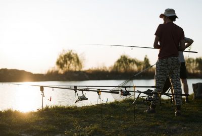 Fishing as recreation and sports displayed by fisherman at lake Fishing as recreation and sports displayed by fisherman at lake during sunset