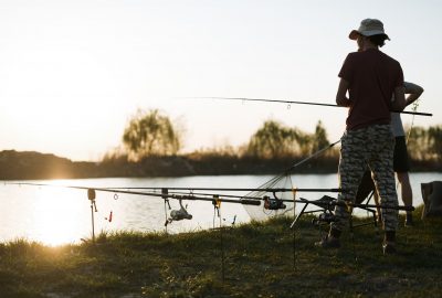 Fishing as recreation and sports displayed by fisherman at lake during sunset