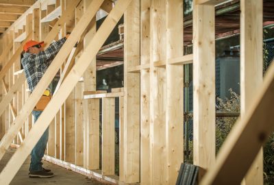 Wooden House Construction Job. Contractor Carpenter Finishing Building wood Beams Frame. Industrial Theme.