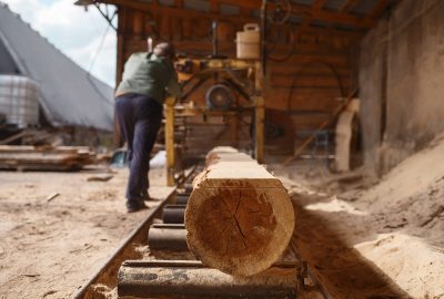 Joiner works on woodworking machine, lumbering Joiner works on woodworking machine, lumber industry, carpentry. Wood processing on factory, forest sawing in lumberyard, lumbering